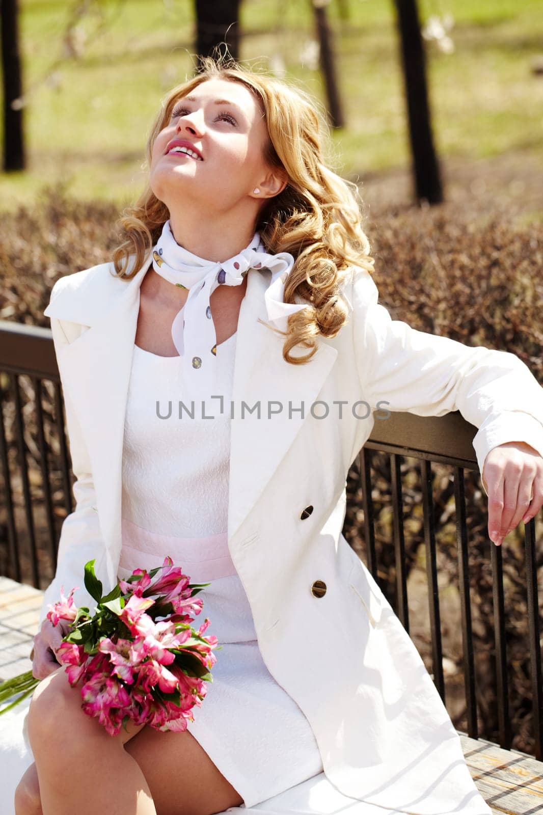 Portrait of a young woman sitting on bench and looking up