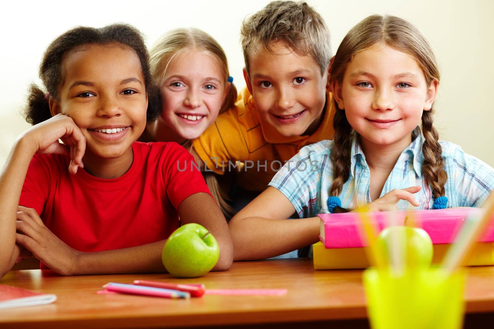 Portrait of smart schoolchildren looking at camera in classroom