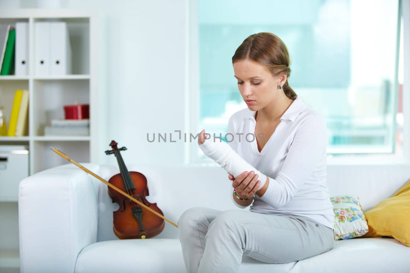 Portrait of a young violinist touching her broken arm
