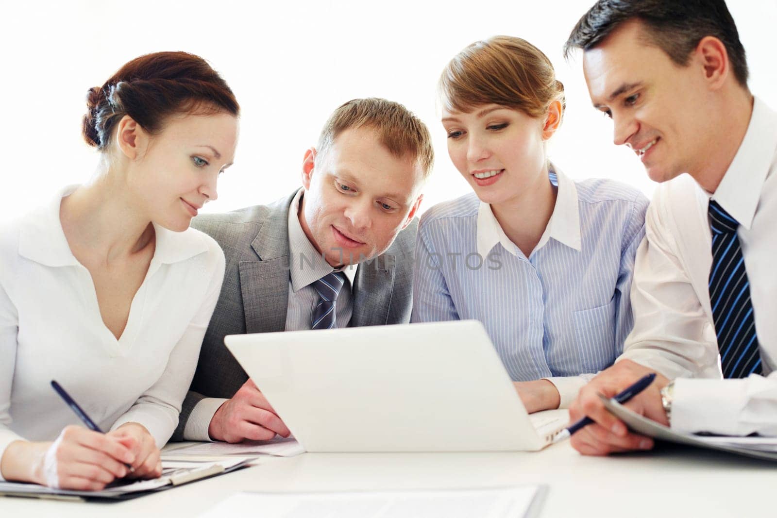 Four business people working with laptop in office