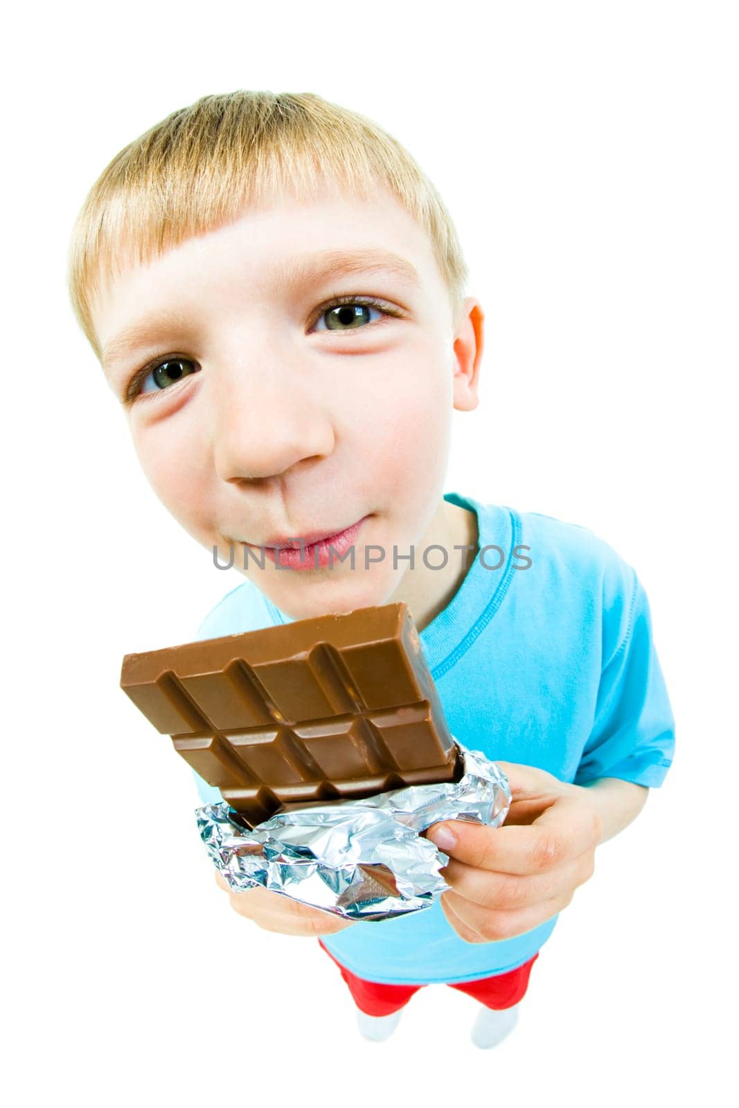 Portrait of happy boy with bar of chocolate in hands looking at camera
