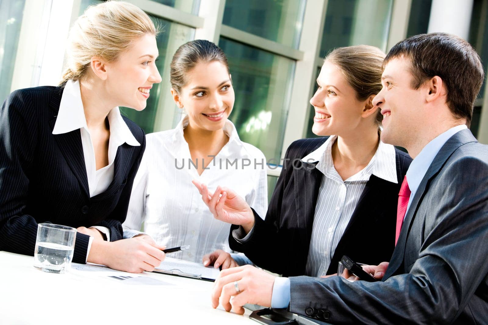 Portrait of four white collar workers discussing a new plan