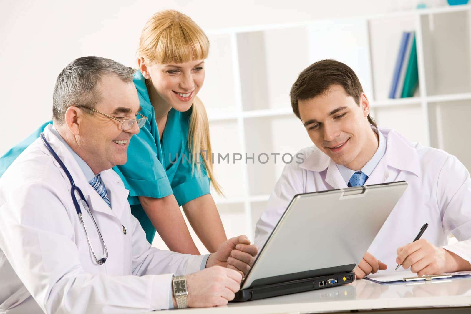 Group of therapists looking at laptop screen and discussing new method of treatment