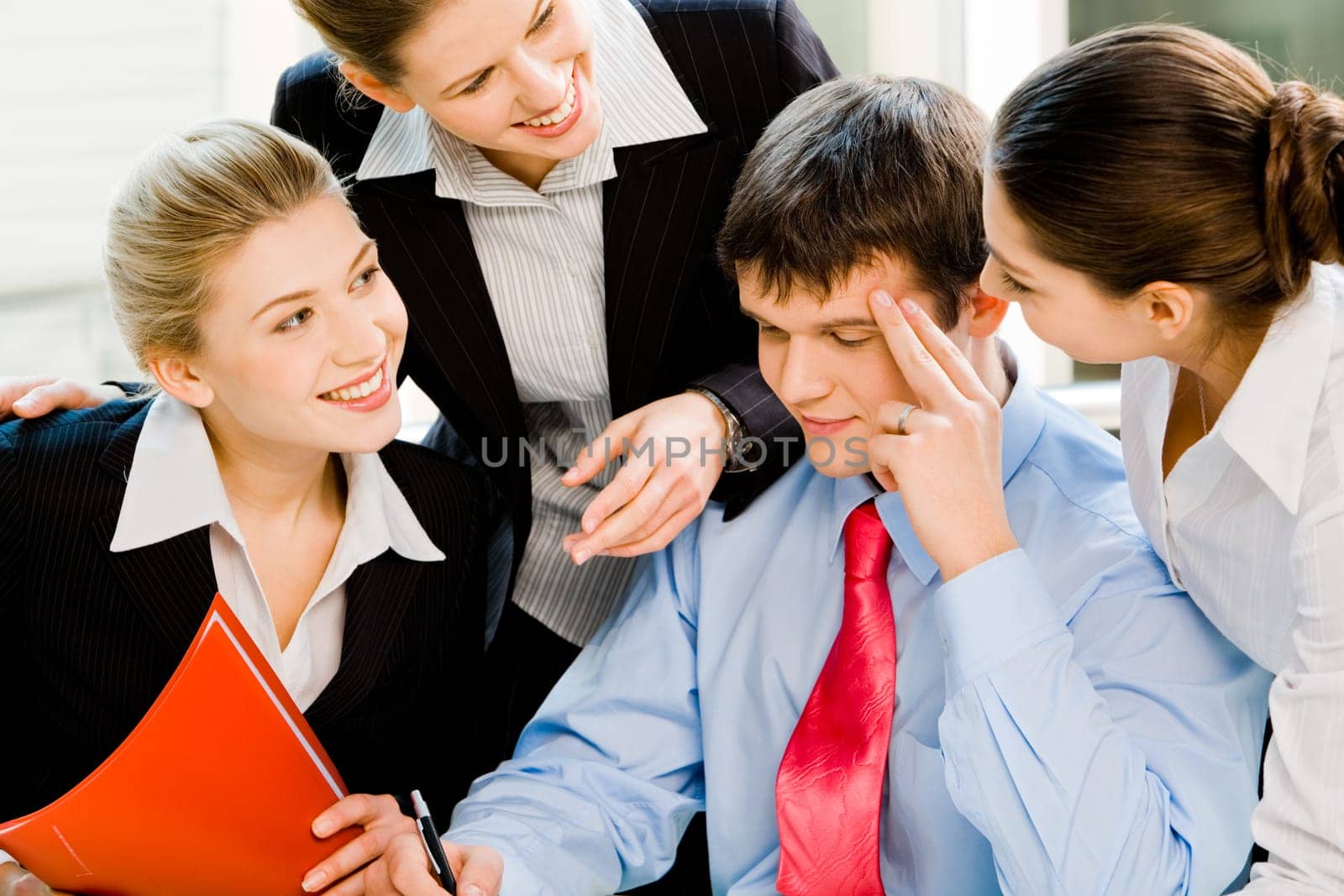 Three business ladies smiling at the thinking man