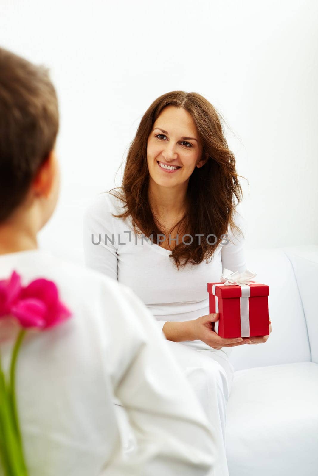 Happy woman with giftbox looking at her son and smiling