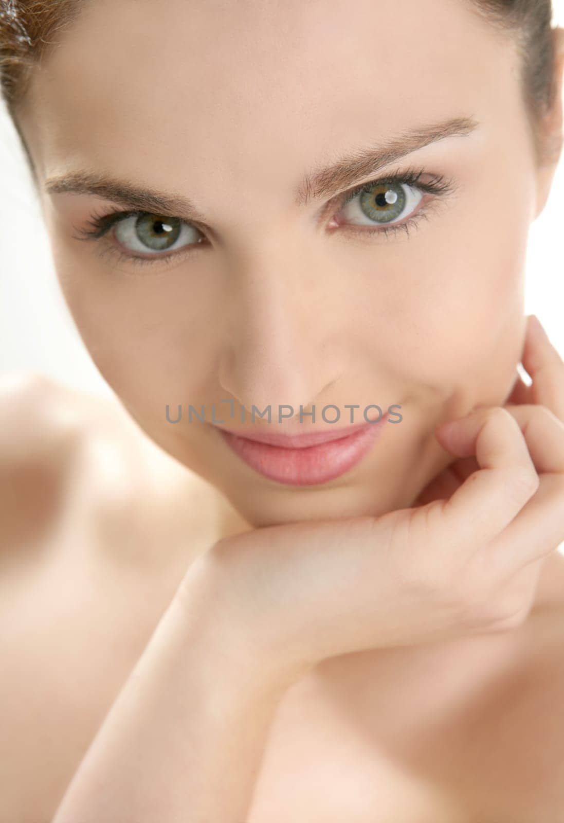 Beautiful woman portrait with hands on head isolated on white at studio