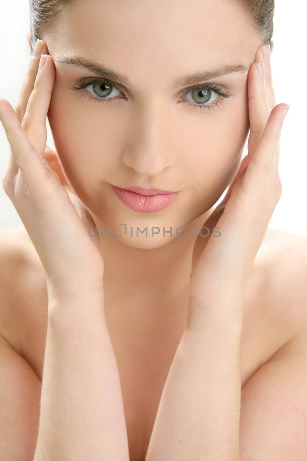 Beautiful woman portrait with hands on head isolated on white at studio