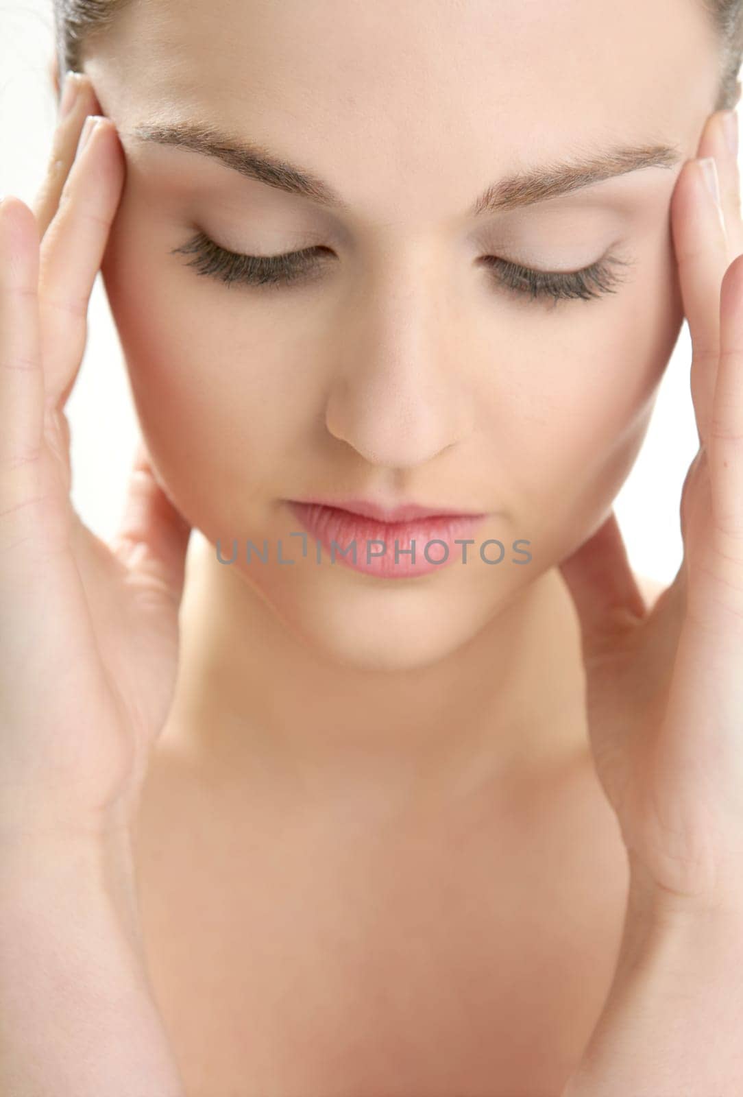 Beautiful woman portrait with hands on head isolated on white at studio