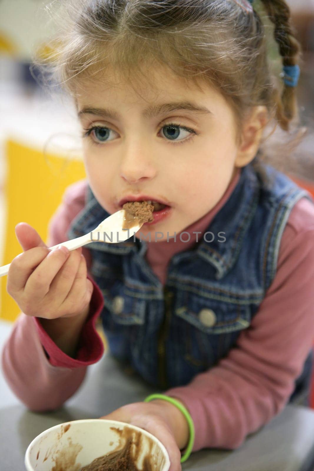 Sweet girl gets dirty eating chocolate ice cream with spoon