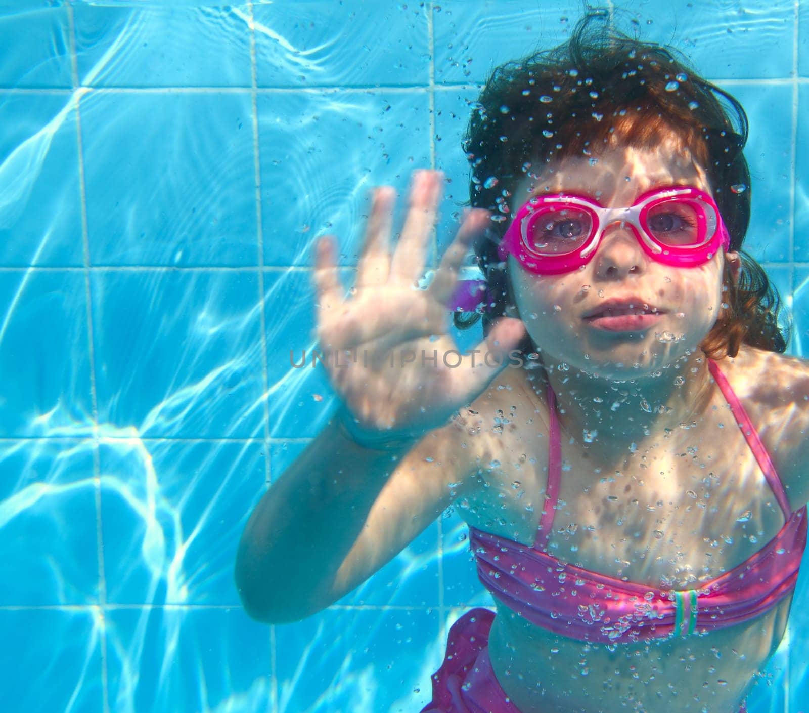 underwater little girl pink bikini goggles blue swimming pool
