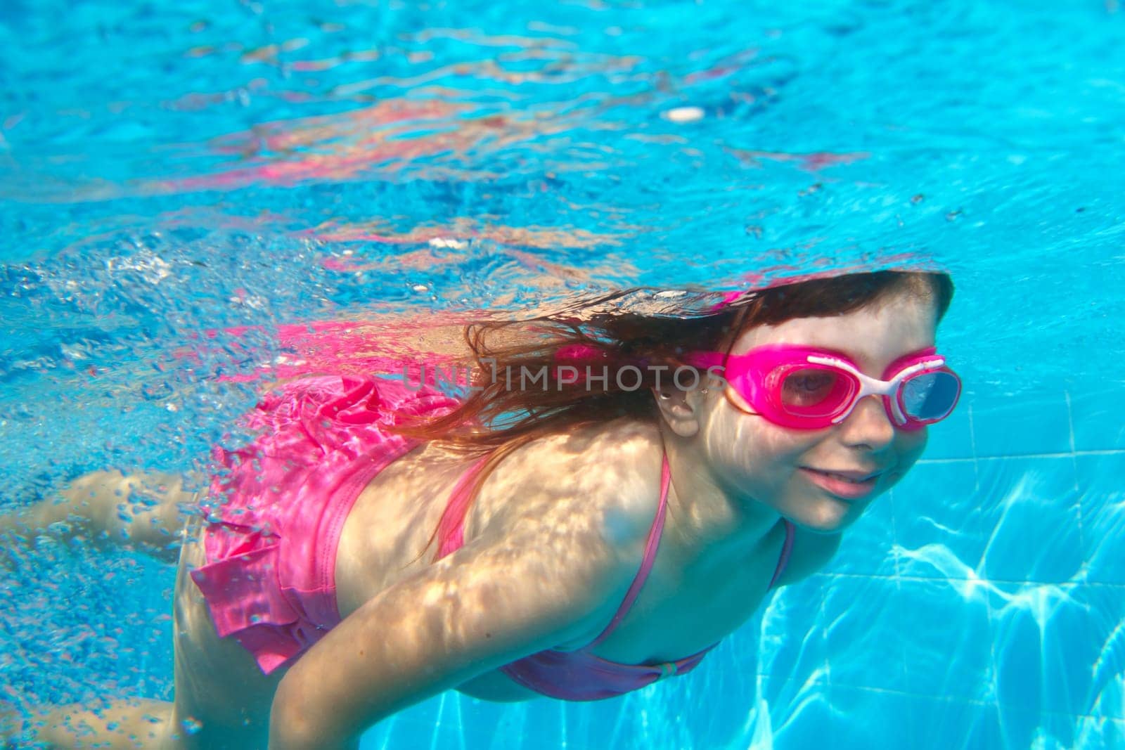 underwater little girl pink bikini goggles blue swimming pool