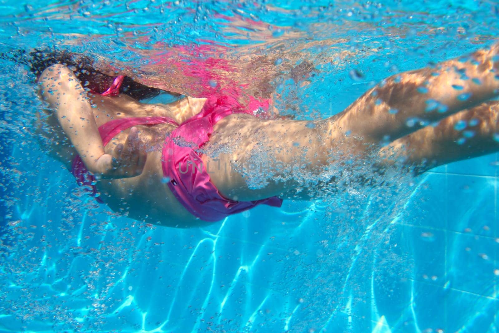 underwater pink bikini little girl swimming in blue pool
