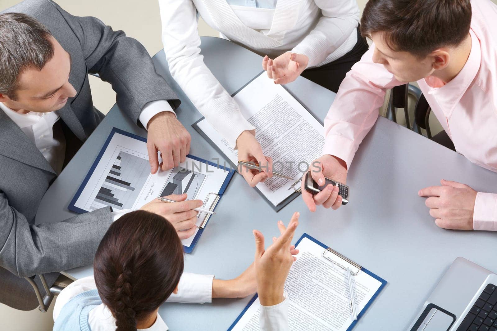 Four businesswomen sitting at table examining some documents