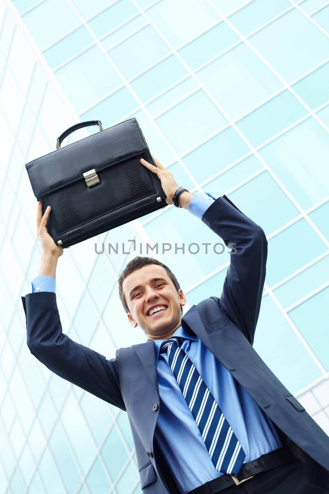 Portrait of young businessman with briefcase looking at camera and smiling