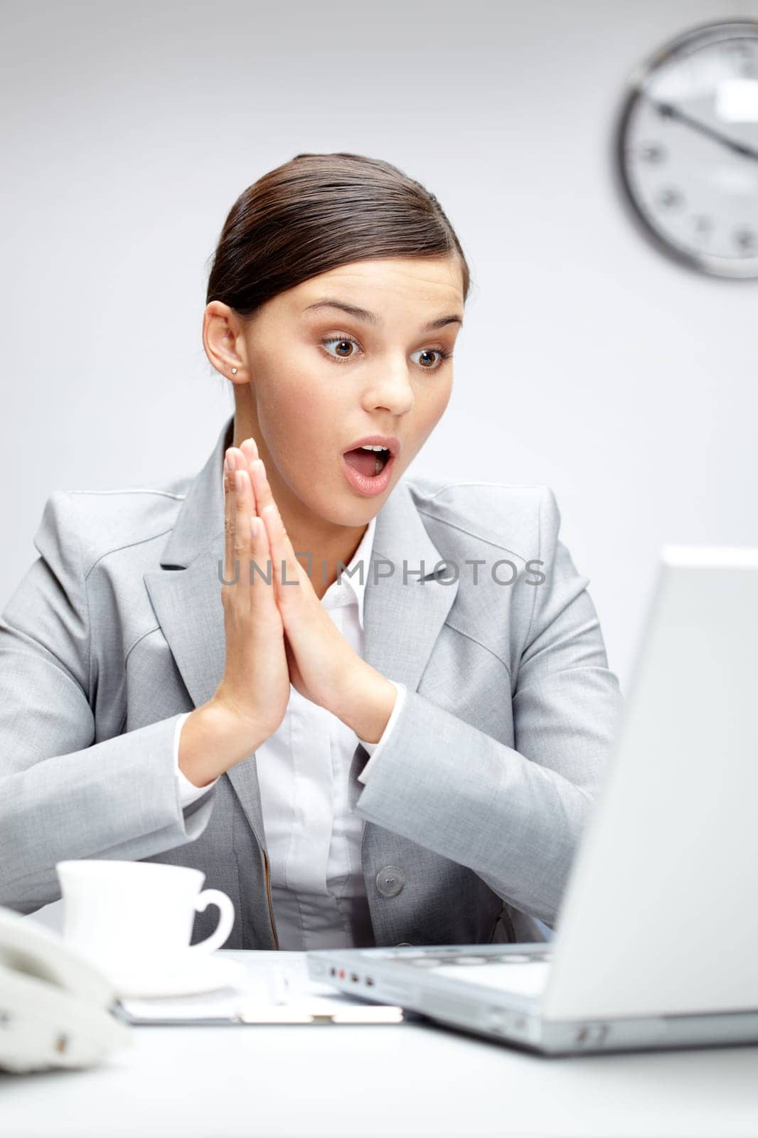Image of young employer looking at laptop with surprise in office