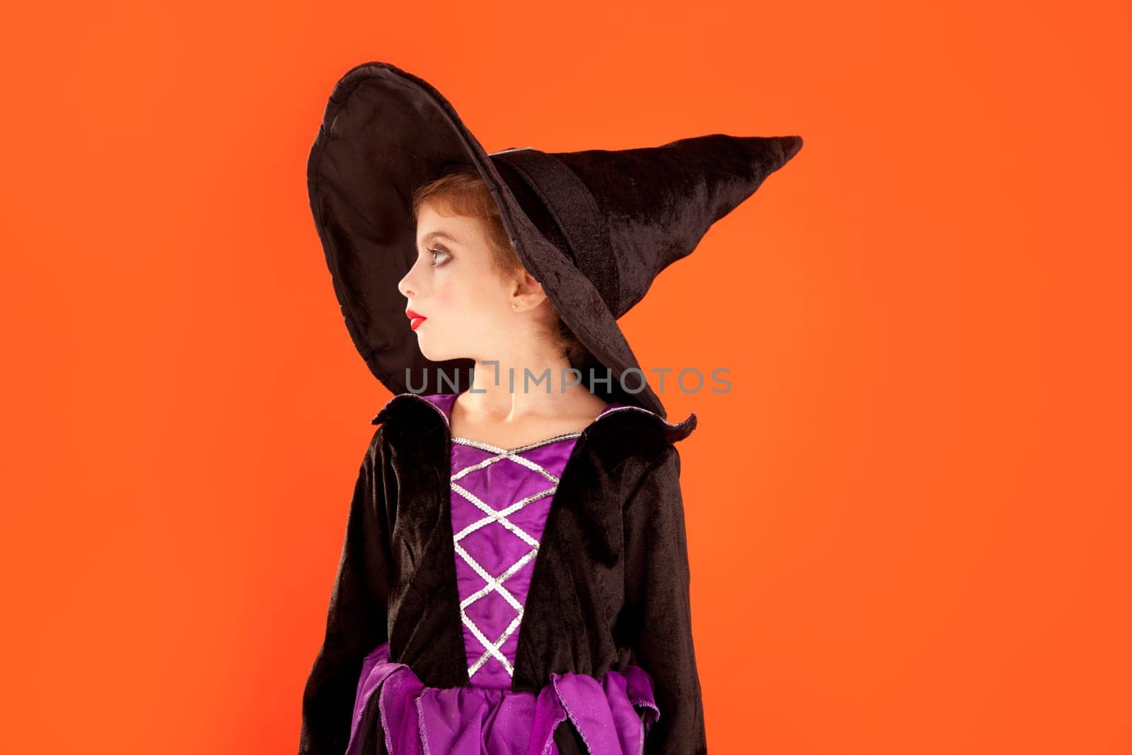 Halloween kid girl costume on orange background
