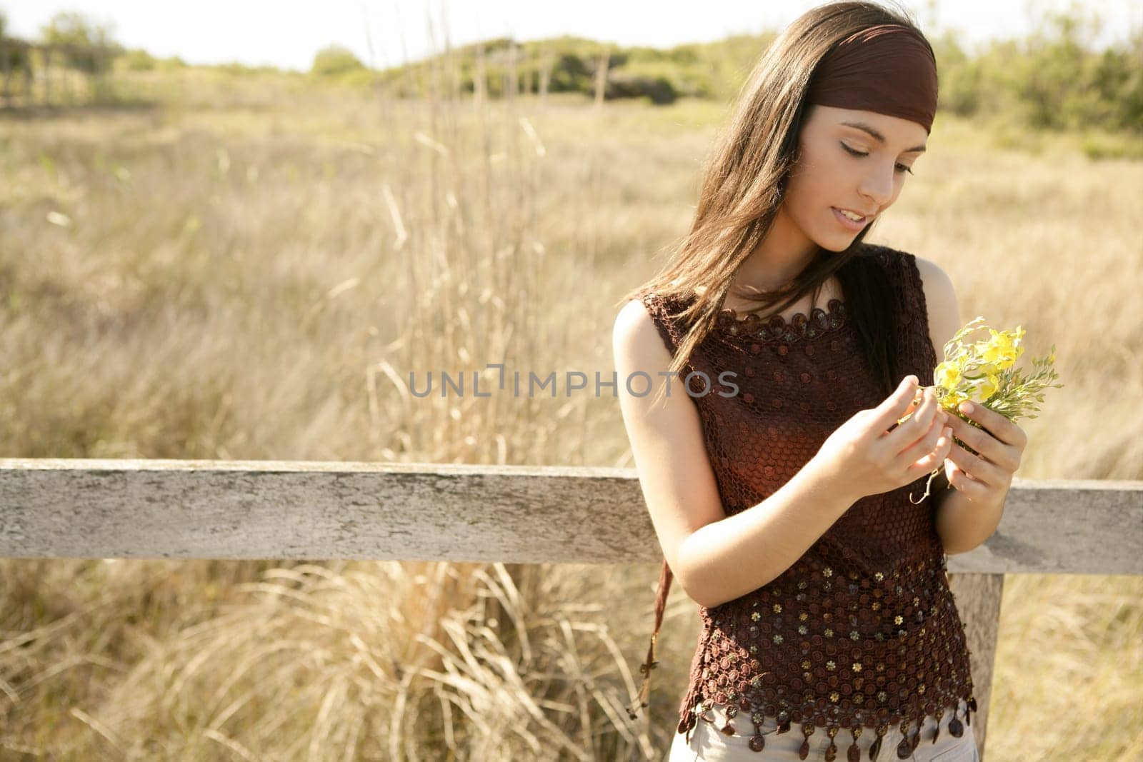Beautiful woman in golden outdoor with yellow flower