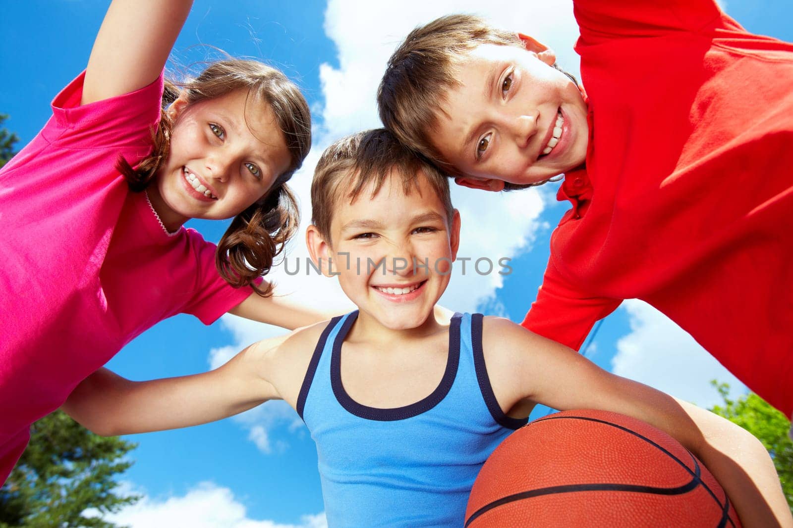 Below view of three little friends looking at camera and smiling