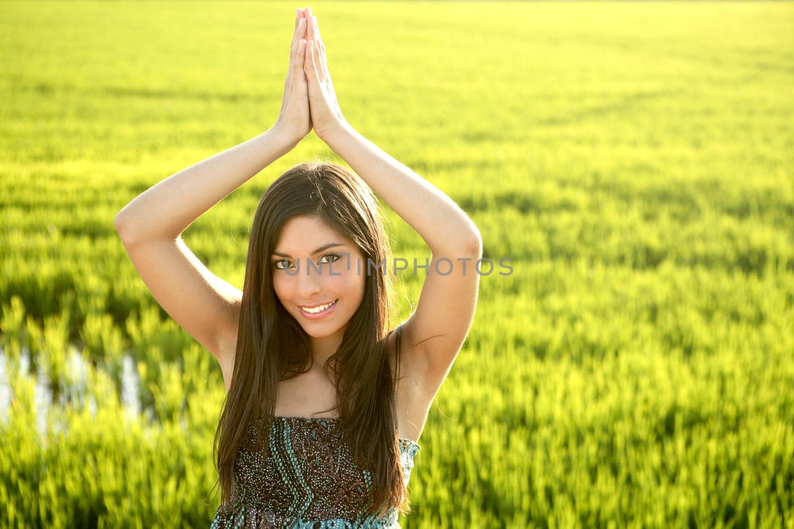 Beautiful brunette indian young woman in the green rice fields meadow