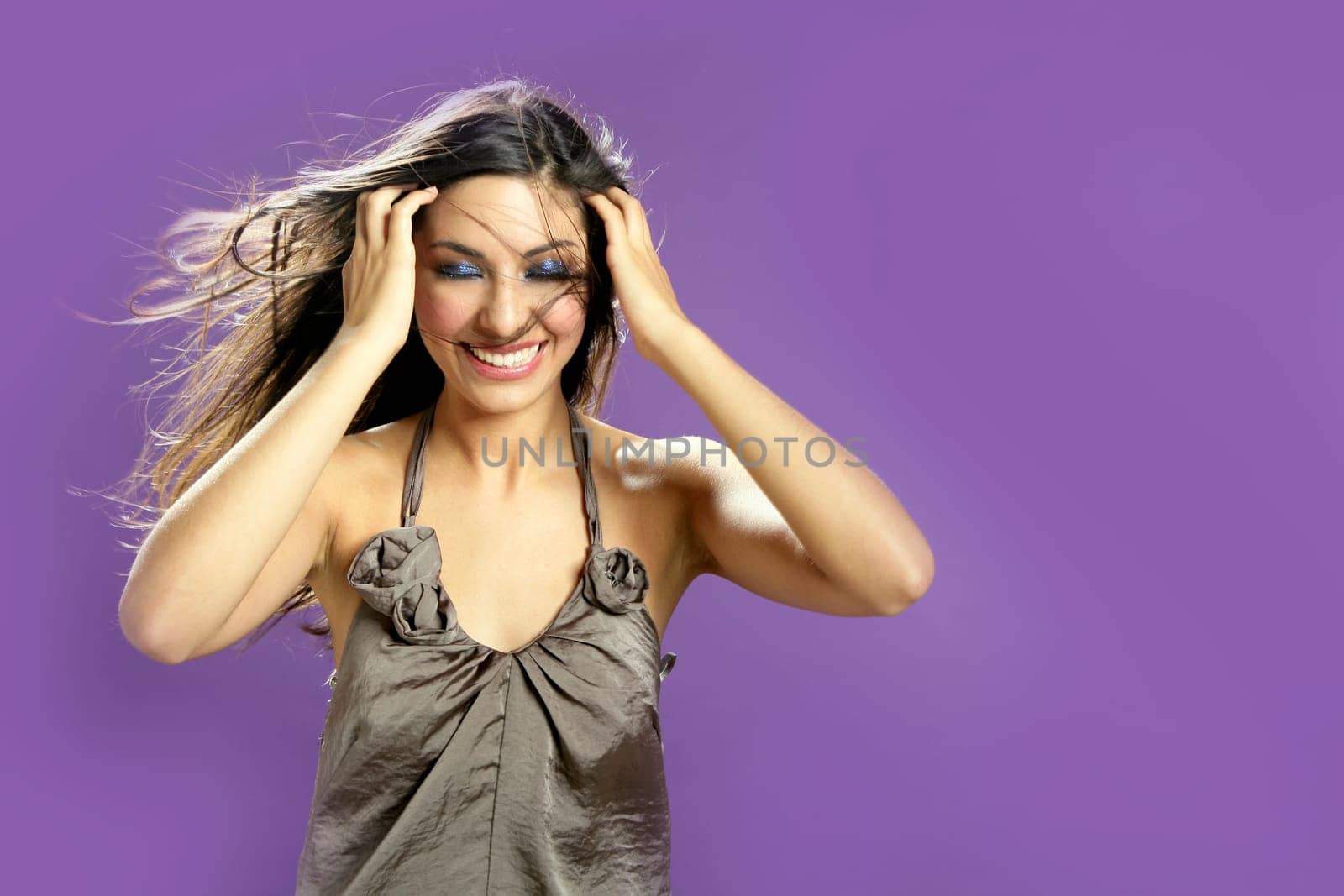 Brunette indian beautiful woman dancing at studio on purple background