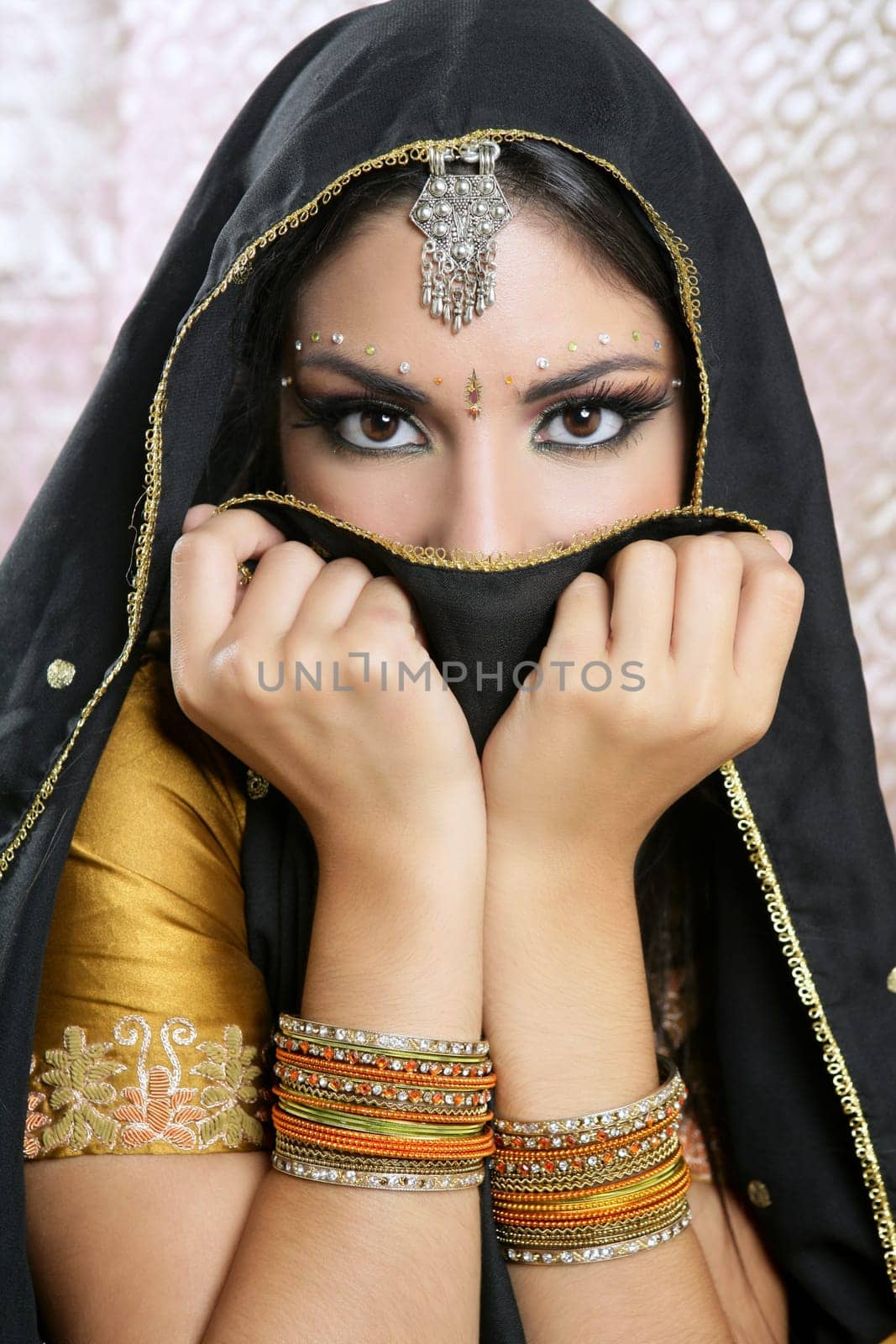 Beautiful brunette asian girl with black veil on face, traditional indian costume