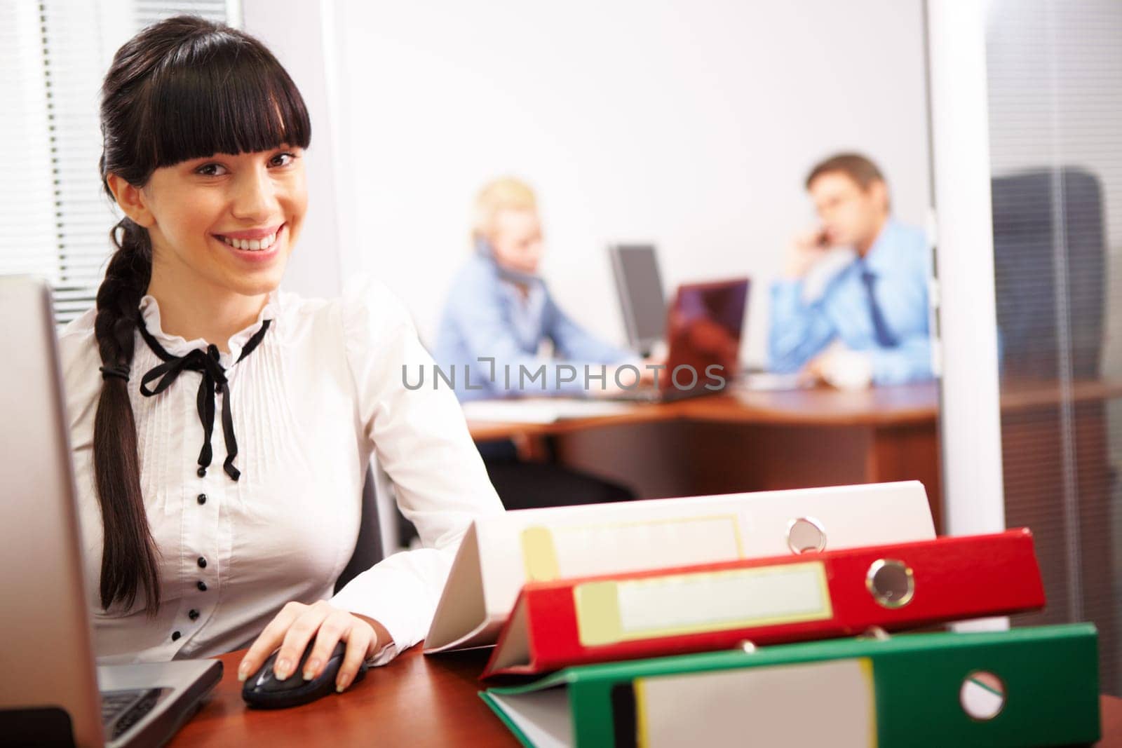 Busy secretary looking at camera in the office