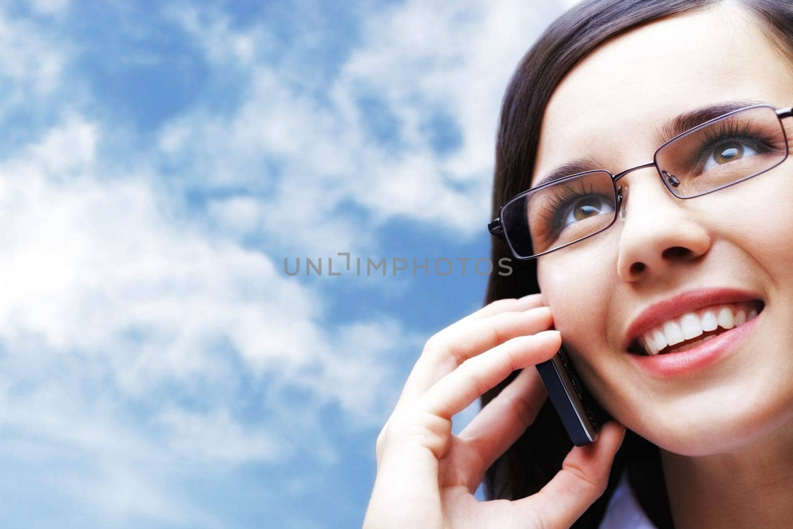 Photo of smart businesswoman talking by mobile phone with cloudy sky on background