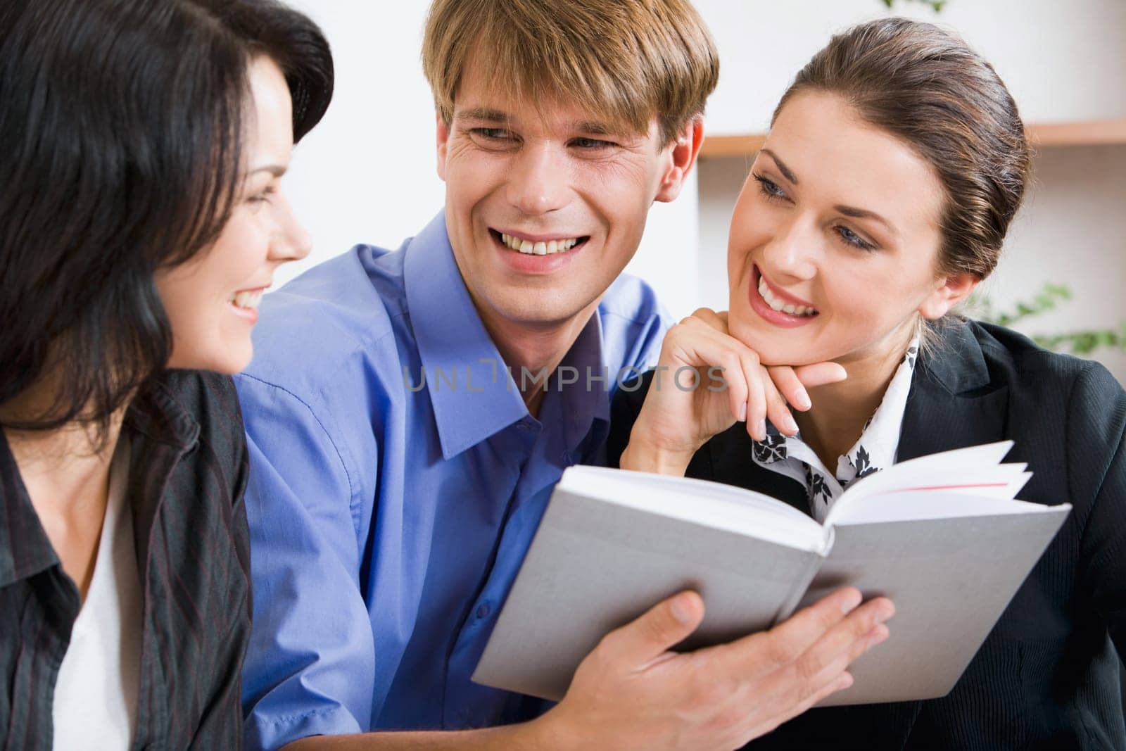 Business man holding the notepad between two women