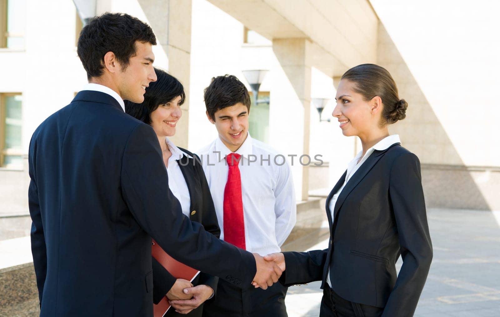 Photo of successful associates handshaking after striking deal outdoors at meeting