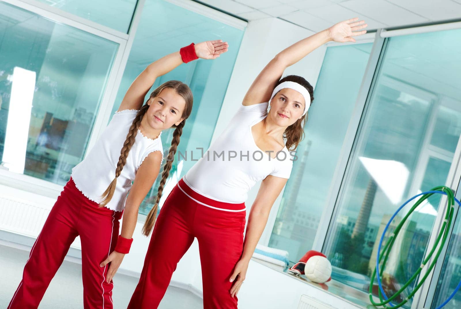 Portrait of healthy female and her daughter practicing physical exercise