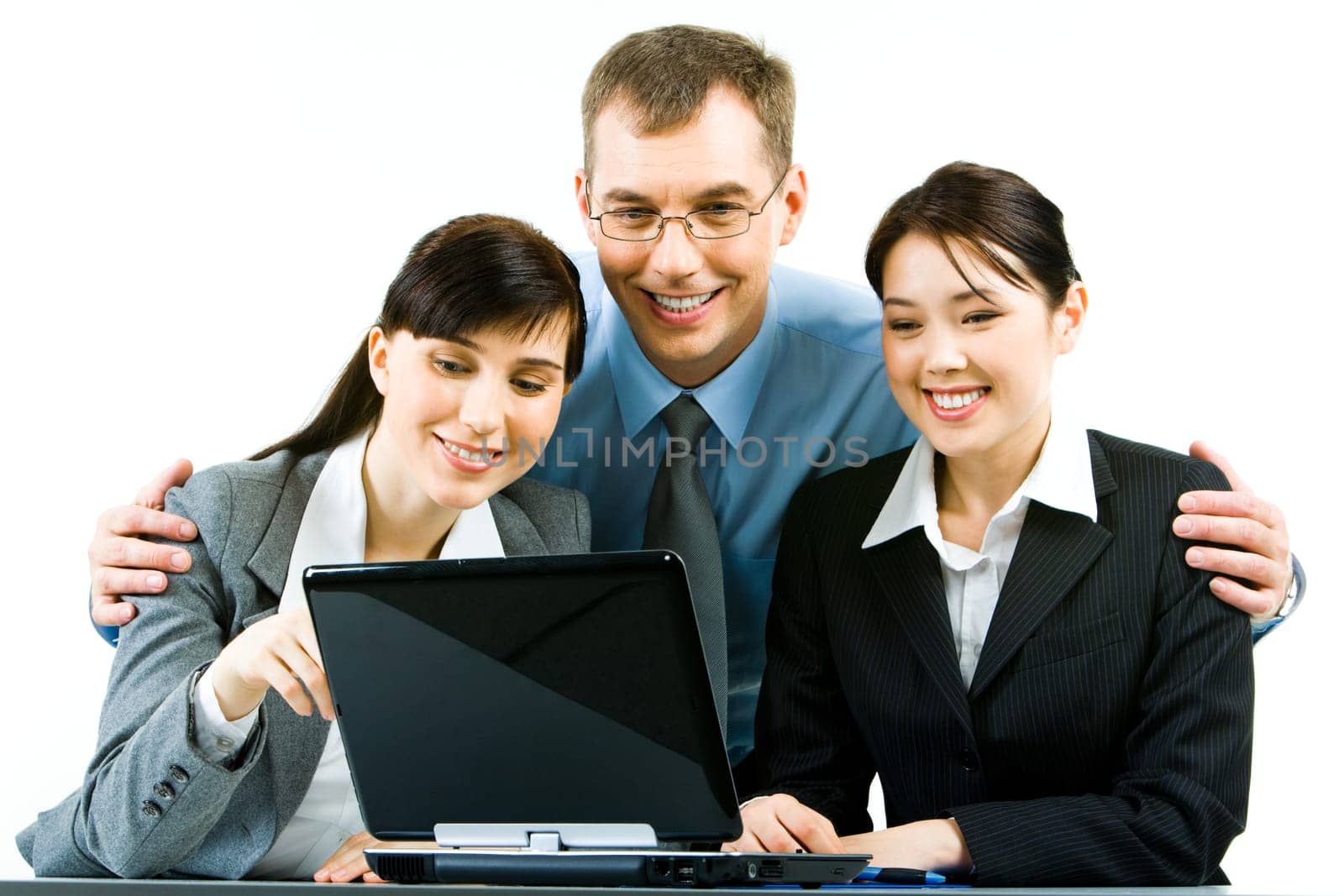 Portrait of smiling young woman sitting at the table with their leader standing behind them and looking at laptop screen together