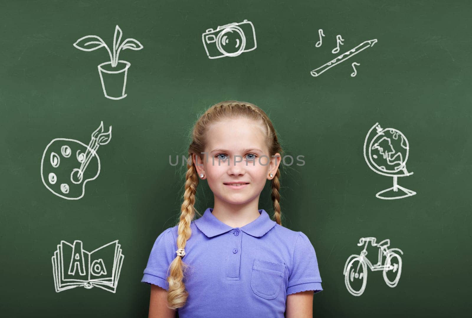 Portrait of smart girl by the blackboard looking at camera