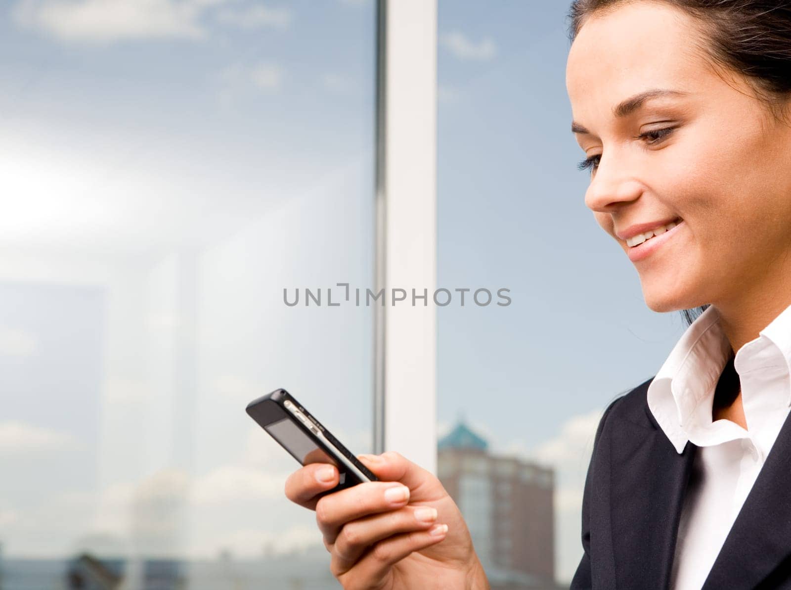 Image of pretty woman holding her mobile and sending sms