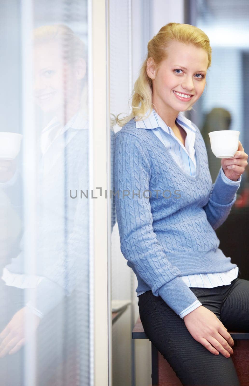Portrait of a young beautiful businesswoman sitting on table with coffee