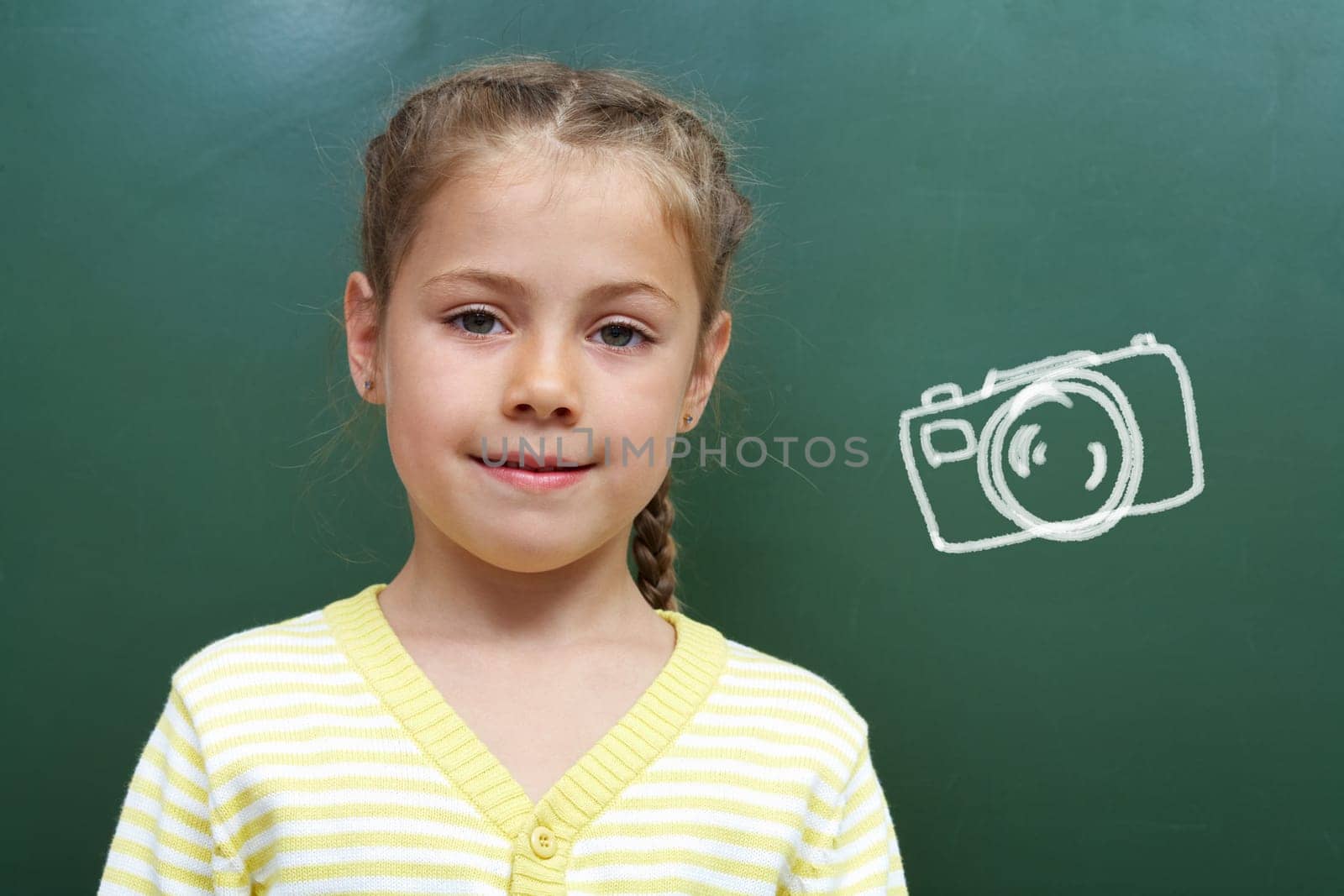 Portrait of smart lad by the blackboard looking at camera