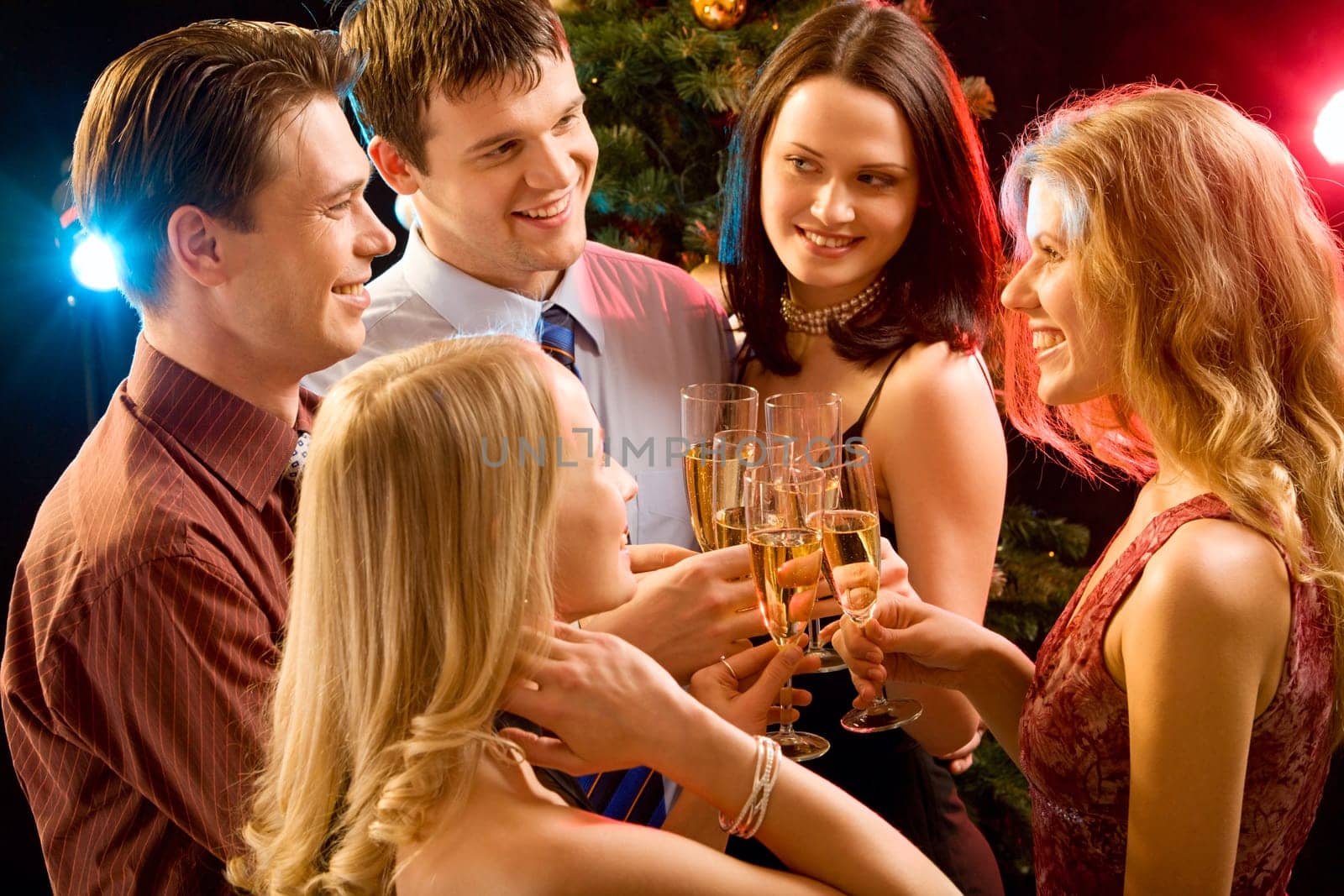 Photo of five smiling friends touching their glasses with each other at christmas