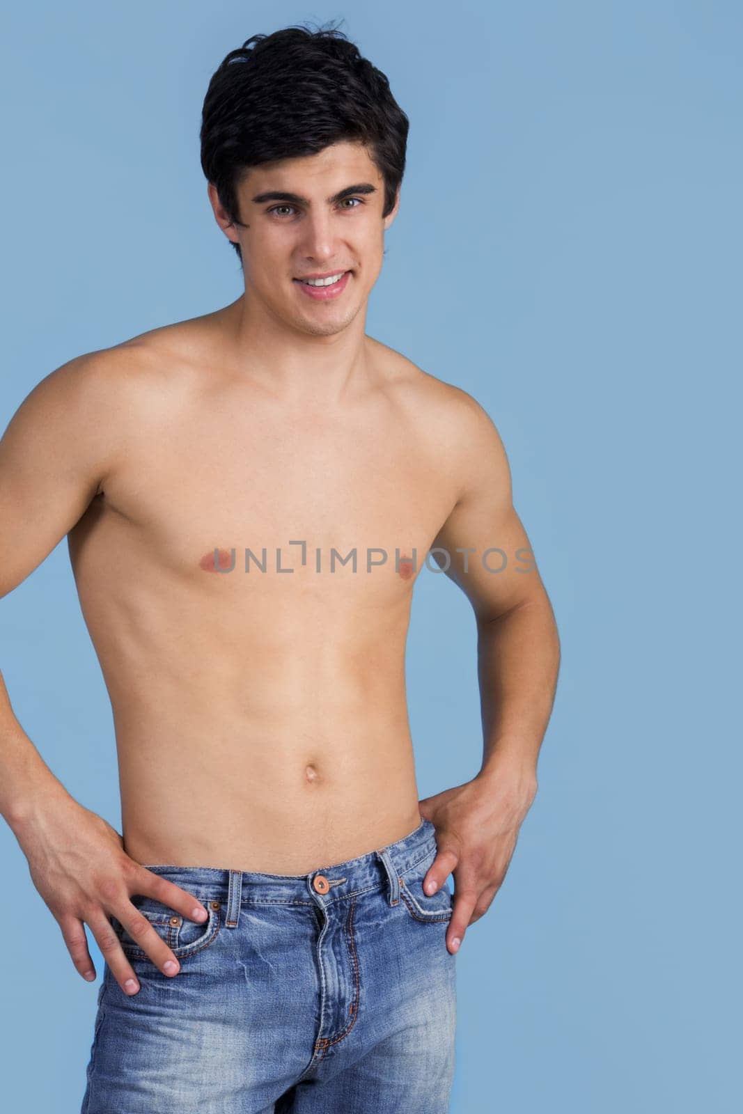 Portrait of handsome lad looking at camera over blue background