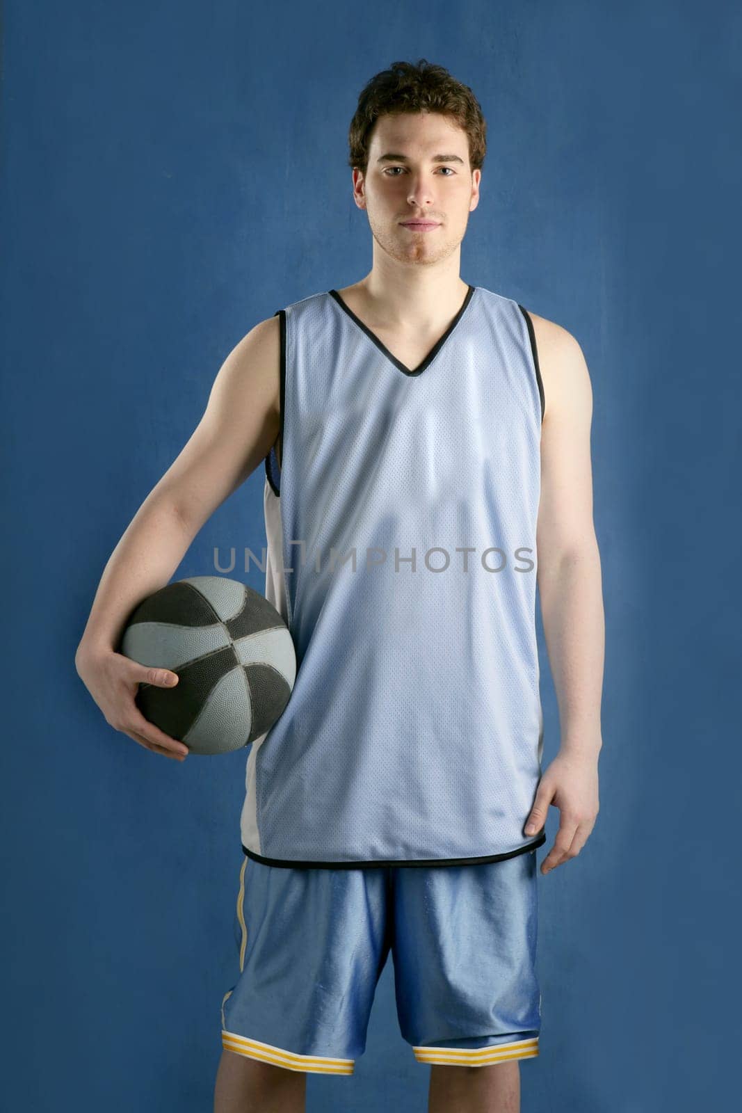 Basket player young man over blue grunge background