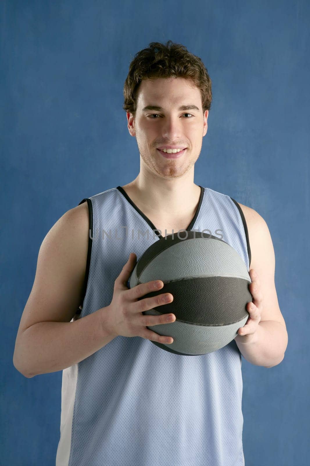 basketball young man basket player portrait over blue studio background