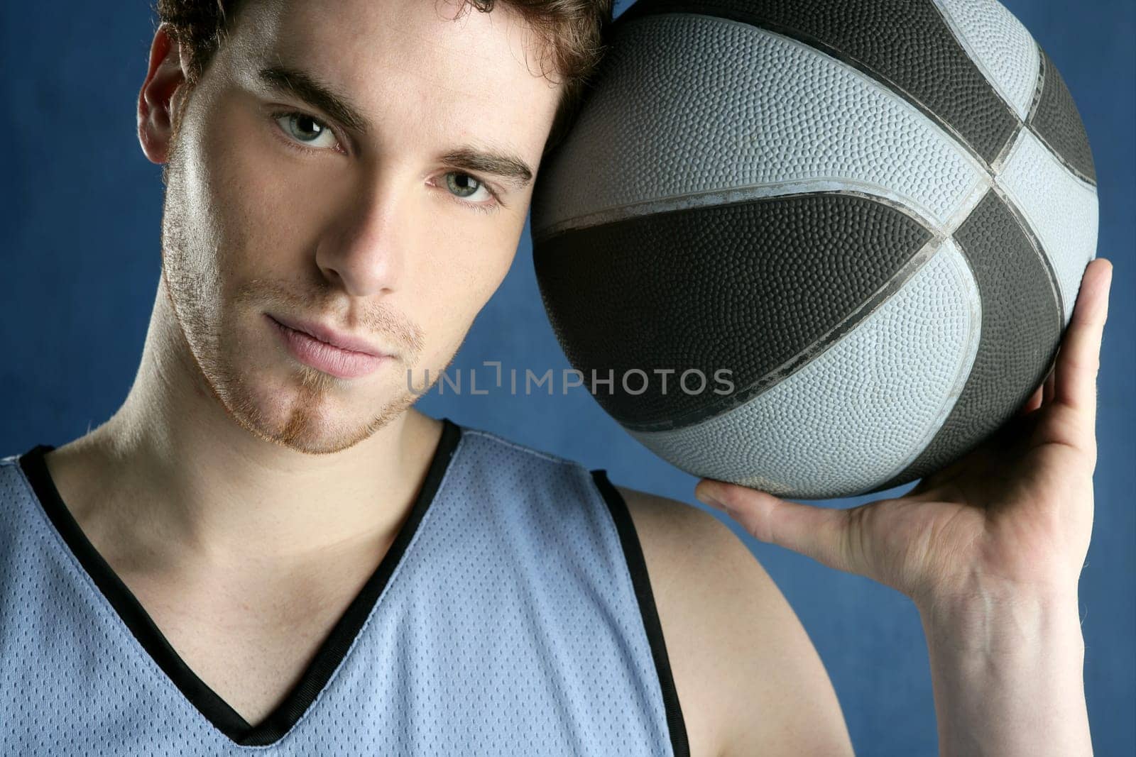 Basket player young man over blue grunge background