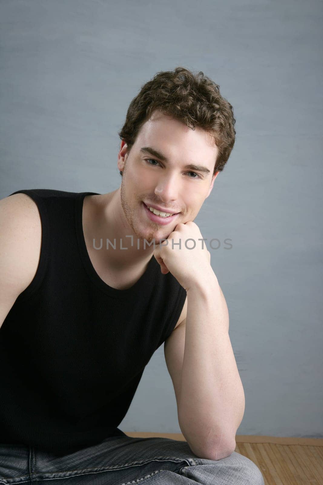 casual young man portrait sit over gray grunge background