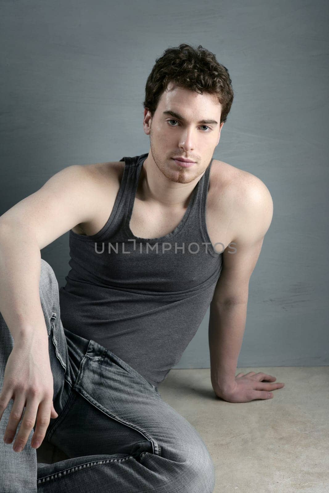 casual young man portrait sit over gray grunge background