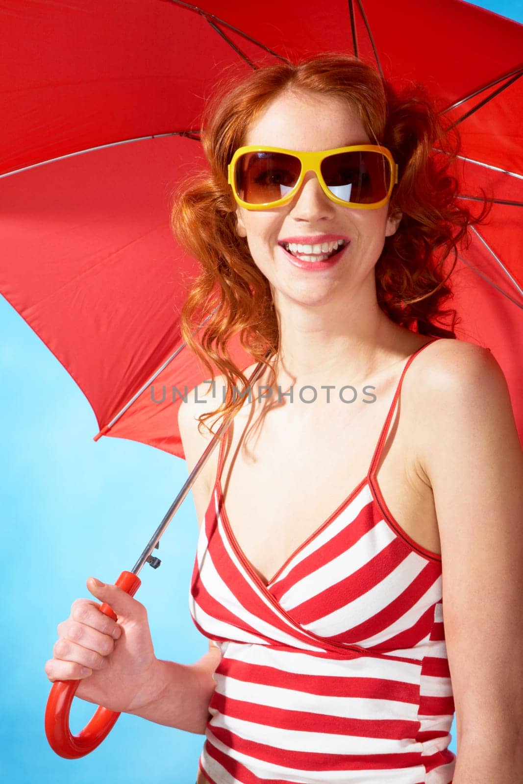 Portrait of elegant woman in sunglasses under umbrella