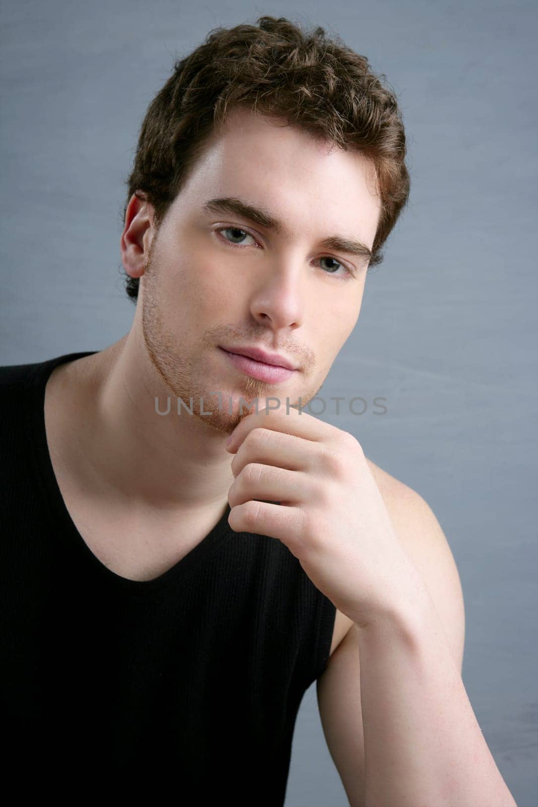 young man portrait posing looking camera over gray background