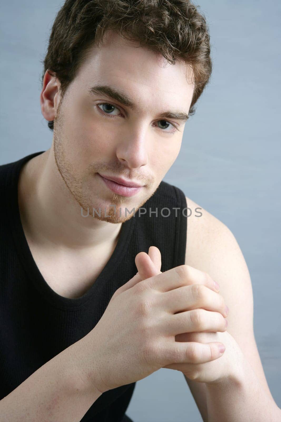 young man portrait posing looking camera over gray background