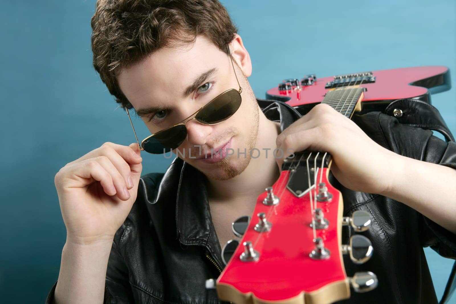 guitar rock star man sunglasses and leather perfect jacket over blue