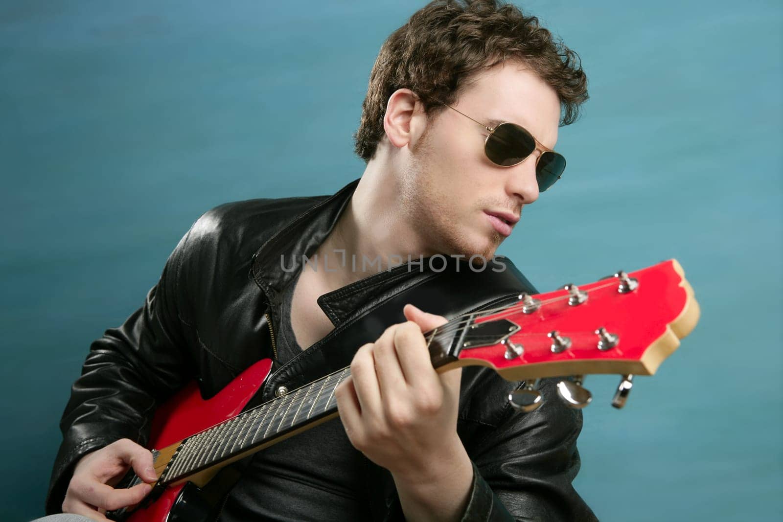 guitar rock star man sunglasses and leather perfect jacket over blue