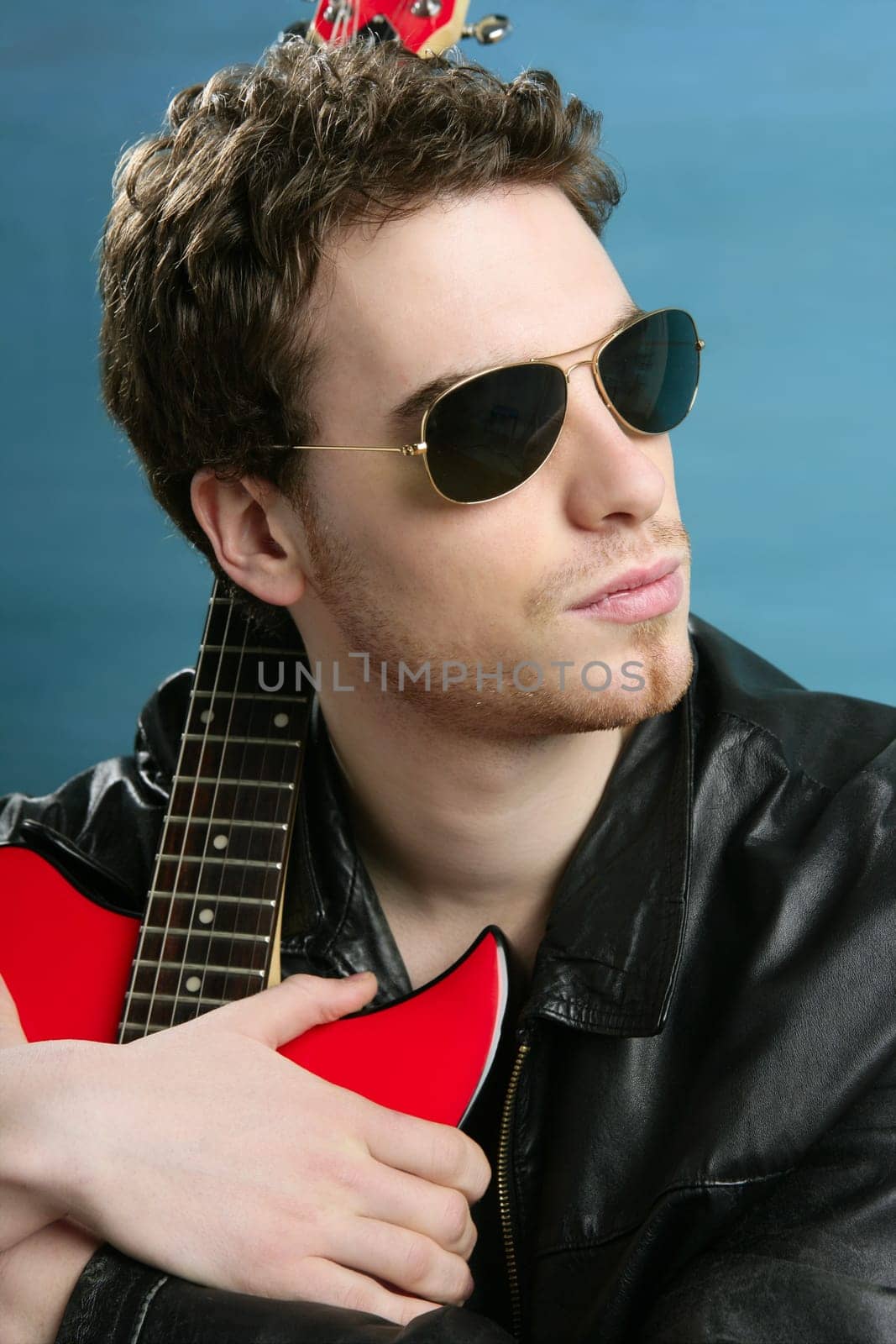 sexy rock man sunglasses and leather black jacket over blue