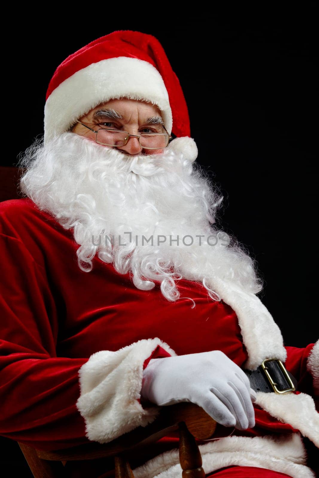 Santa sitting and smiling isolated on black