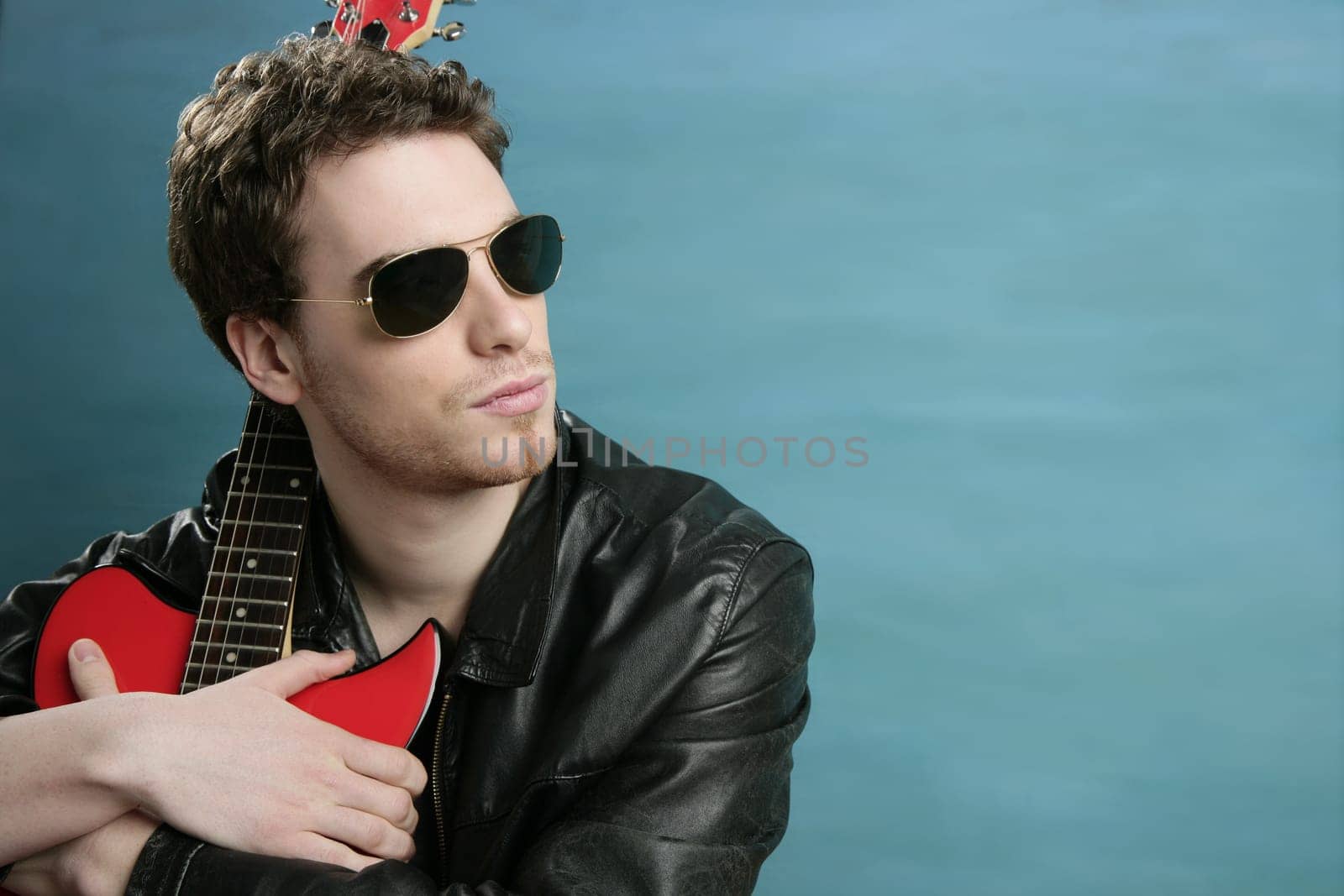guitar rock star man sunglasses and leather perfect jacket over blue